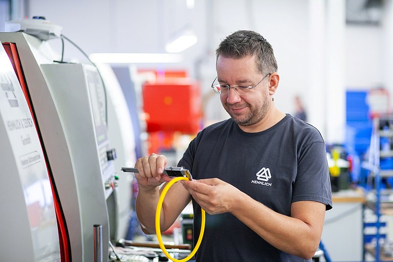 Alexander Pucher, CNC-Dreher bei HENNLICH, bei der Arbeit an einer CNC-Maschine