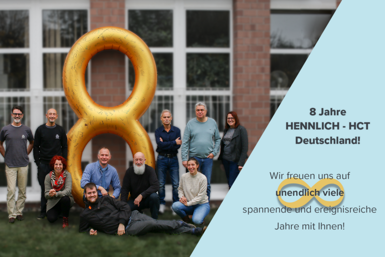 Mitarbeiter stehen um eine riesige Ballon-Acht