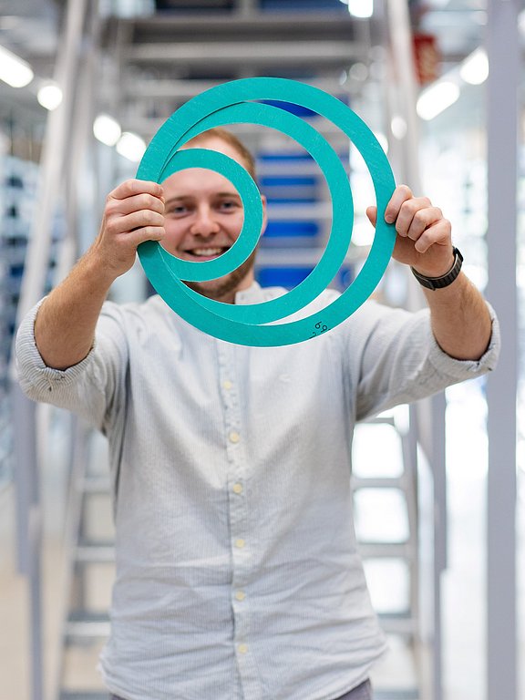 Nico Smuda, Techniker bei HENNLICH, hält 3 Flachdichtungen in beiden Händen