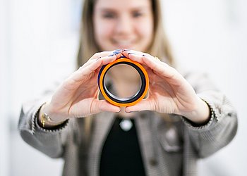 Simone Rakaseder hält Hydraulikdichtung in beiden Händen | HENNLICH